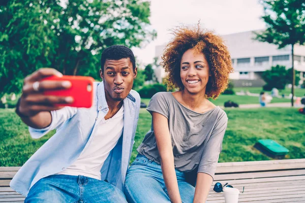 Joven Atractiva Mujer Alegre Preguntándose Mientras Amigo Masculino Haciendo Autofoto — Foto de Stock