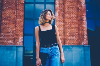 Şık Eyewear trendy kıyafeti kentsel ayarı arka plan üzerinde boş zaman açık havada duran tadını muhteşem hippi kız şehir sokak, yürürken defter tutan çekici kız öğrenci