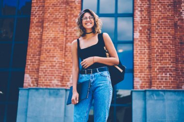 Sırt çantası ve güneşli bir bahar günü, güzel kız öğrencinin üniversite kampüs gülüyor içinde vakit zevk moda giyim giyinmiş sırasında sokakta geziniyor defter ile mutlu hippi kız