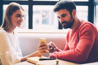 Mutlu genç hippi kız erkek arkadaşıyla birlikte smartphone cep telefonu ile uygulama, birlikte vakit aşık çift üzerinden arama restaurant için dating online alışveriş yapma web mağaza sitesini gösterilen