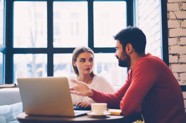 Dizüstü bilgisayar kafe Ardiles seçerek online fiyatları ve konaklama hakkında konuşmak serbest zaman sırasında rezervasyon için oteller arkadaş kullanarak web mağaza alışveriş yaparken tartışma aşık Çift