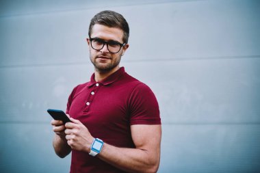 Gözlük kamera sırasında instaling yeni mobil uygulama modern telefonu bakarak yakışıklı şık adam yarım uzunluk portre. Hippi kız sohbet online Smartphone'da gözlükler