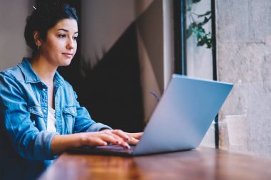 Genç çekici metin yazarı aracı uzaktan çalışma sırasında müşteriye e-posta göndererek modaya uygun kıyafet giymiş. Sunu yaparken web sayfasında bilgi arama muhteşem yetenekli öğrenci