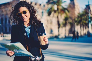 Neşeli kadın kişi dışında gezinme sırasında gezi hedef haritası arıyorsunuz trendy moda kıyafetler giymiş. İyi bir ruh hali ve kahve ile dinlenme zevk şirin mutlu traveler
