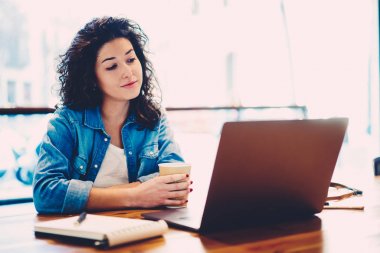 Yetenekli kadın grafik tasarımcı yararlı eğitim webinar Web sitesinde dizüstü bilgisayar içinde izlerken kablosuz internet'e bağlı. Kafede mola sırasında ilginç film zevk çekici öğrenci