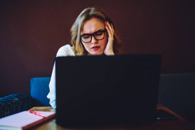 Dizüstü bilgisayar, yetenekli erkek tasarımcı bilgi yeni web projesi için sıkılmış okuma ve overworked önünde oturan duygu çalışma zor bir görev üzerinde konsantre profesyonel metin yazarı yorgun