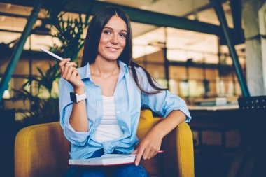 Müreffeh işkadını notlar çalışma programı, Not Defteri'nde yaratıcı fikirler yazmak için hazırlama projesi için neşeli kadın planlama strateji portresi nedeniyle Organizer'da kontrol kamera bakıyor