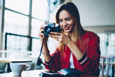 Ağlar resimlerde yüklemek için vintage fotoğraf makinesi fotoğraf çekmeye neşeli profesyonel kadın fotoğrafçı. Pozitif yetenekli genç kadın amatör fotoğrafları eğlence hobi üzerinde harcama yapma