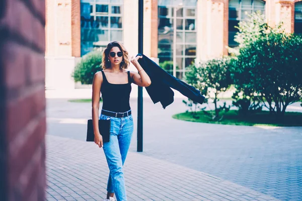 Allvarlig Attraktiv Kvinna Fritidskläder Som Lyfter Jacka Medan Promenader Ort — Stockfoto