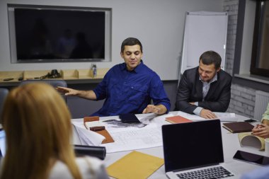 Girişimcilik ve yenilik finans şirketi sahte alanı ile kablosuz internet'e bağlanan dizüstü bilgisayar ile tablo toplantı oturan geliştirme hakkında konuşurken çalışanları ile birlikte gurur ceo