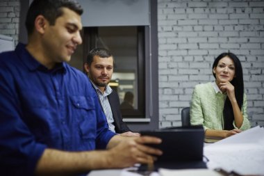 Office'te çalışma sürecinde modern dokunmatik yüzey meslektaşlarına videoda ilginç erkek tasarımcı gösterme. Yaratıcı Mimarlar izlerken Webinar dijital Tablet ve teamworking grafiği oluşturma