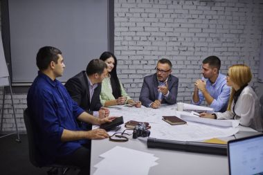 Yaratıcı ve erkek çalışan oturum beyin fırtınası sırasında sorunları çözme grubu. Profesyonel ekip deneyimli mühendis mimari çizimler ile birlikte olgun yönetmen olarak çalışıyor