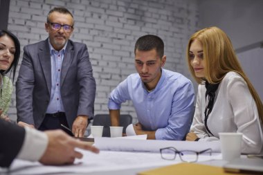 Birlikte iş başlangıç projesi üzerinde çalışan ve birbirleriyle iletişim kurmak ofisinde oturum beyin fırtınası sırasında ekip üyeleri hayal ediyorum. Mürettebat yeni planlama ofisi oluşturma profesyonel mimarlar