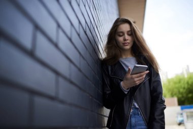 Dalgın çekici hippi kız video izlerken ve sosyal ağlar için reklam kopya alanı alanının yakınında sokak ayakta üzerinde gezinme sırasında açık havada 4 g bağlantısı kullanarak multimedya dosyaları paylaşma