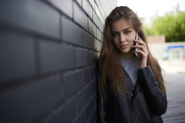 Telefon konuşma ayakta açık havada sokak, şehir yaparken kameraya seyir çekici hippi kız portresi konsantre mobil arama yapmak için gezici bağlantı kullanan genç kadın