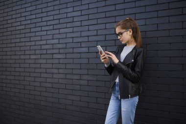 Arama numarasına akıllı telefon, sosyal ağ üzerinden hızlı 4 g internet bağlantısı açık kulaniyi kendi kendine güvenen genç hipster üzerinde reklam promosyon arka plan üzerinde duran genç kız öğrenci