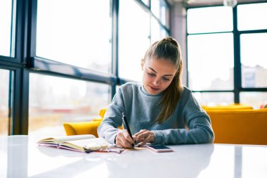 Neşeli genç kız öğrencinin eğleniyor sosyal ağlarda sohbet telefon Kitaplığı'nda eğitim üzerinde komik videolar izliyor. İletiyi başarılı proje ile ilgili alan duygu mutlu iş kadını heyecanlı