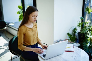 Dalgın kız öğrenci dizüstü bilgisayarda, yetenekli yazarı çevrimiçi marketin için yayın oluştururken alanı coworking uzak iş web sitesi tarama raporu bilgilerini arama