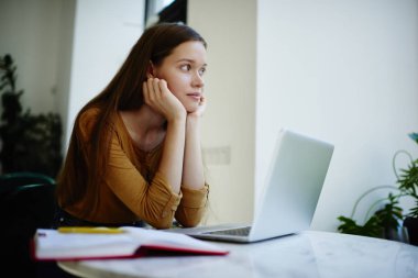 Hafta sonları düşünmeye pencere bakarak rüya gibi hippi kız ev ödevi görevi, yaratıcı metin yazarı lapto boşlukla coworking oturan proje pazarlama için fikir üzerinde durulması yapmak zorunda