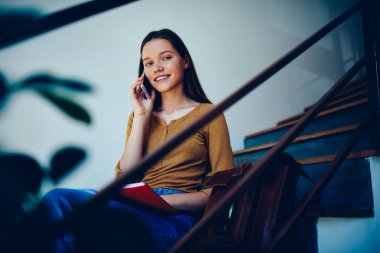 Otururken kampus içinde merdivenlerde dersler sonra güzel hippi kız Üniversitesi'nde toplantı için telefon bekleyen arkadaşıyla konuşurken telefon konuşmayı sevimli kız öğrencinin portresi