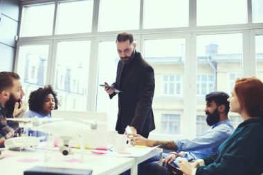 Yakışıklı eğitmen business Management yetenekli çalışan, profesyonel antrenör eğitim ders sırasında aygıt kullanarak modern konferans odasında öğrencilerle konuşma grubu için yapım Atölyesi