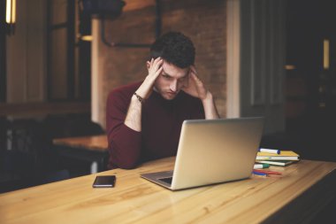 Yakışıklı işadamı dikkatle izlerken ilginç eğitim webinar Web sitesi için 4 g bağlı dizüstü üzerinde yoğunlaşmıştır. İş yerinde sorun çözme hakkında derin düşünme genç yetenekli grafik tasarımcı