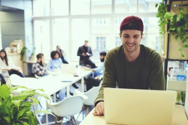 Zeki raslantı giyimli erkek bu geliştirici memnun dizüstü bilgisayarda, neşeli öğrenci ödev için bilgi aramak için Wi-Fi bağlantısı kullanarak kodlama sırasında çalışma görev tamamlanması ile