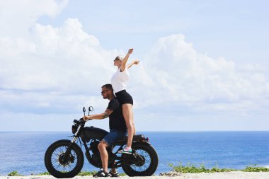 Mutlu genç kadın duygu erkek zevk eğlence ve doğa manzarası, neşeli kaç aşk içinde okyanus kıyısında sürme sırasında heyecanlı macera ile motosiklet sürüş balayı sırasında memnun.