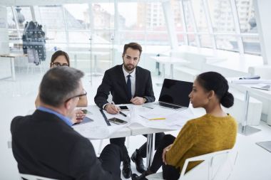 Profesyonel Mimarlar dizüstü kullanarak proje hakkında icra müdürü ile danışmanlık sürecinin çalışma. Resmen işbirliği konferans salonunda görüşme sırasında ayrıntılarını tartışmak iş ortakları