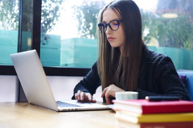 Dalgın esmer öğrenci öğrenme üniversite kampüsü içinde wifi bağlantısı'nı kullanarak Web sitesi tarama yayın oluşturma konusunda yetenekli genç freelancer konsantre kurs bilgileri arama