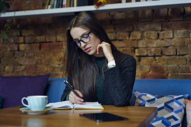 Dalgın çekici genç öğrenci ev ödevi görevi kafede iç hale rakip görev üzerinde yoğunlaşmıştır. Defter accountings kafede üzerinde durulması, yetenekli grafik tasarımcı çizim kroki