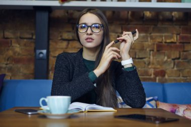 Çekici esmer proje yöneticisi düzenleme ve Cafe, kahve molası grafik harcama Timne oluşturma hakkında düşünme emin yetenekli tasarımcı planlar durulması Eyewear portresi