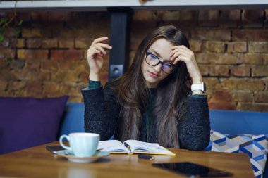 Yaratıcı kadın tasarımcı kafe iç oturma tasarım projesi ile sorunları çözme üzerinde durulması. Not defteri bilgileri analiz güzel genç kadın çalışma işlemi molada konsantre