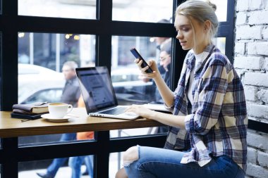 USB'yi dijital cihazlarda raslantı giyimli freelancer göndermesini kafede dizüstü bilgisayar ile multimedya dosyaları eşitleme uygulama çalışmalarını kontrol dalgın yetenekli kadın metin yazarı