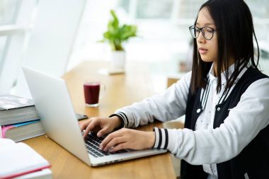 Genç hippi kız yayın akıllı uluslararası öğrenci yapımı online araştırmacılar kurs projesi için yeni bilgi öğrenme dizüstü bilgisayarda yazarak ev ödevi görevi tamamlamadan Eyewear