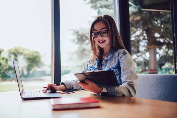 Positive Young Woman Eyeglasses Inputting Data Using Modern Laptop Device — Stock Photo, Image