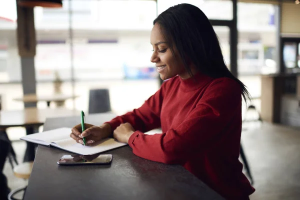 Fröhliche Afroamerikanische Studentin Schreibt Hausaufgaben Café Mit Kreativer Lösung Für — Stockfoto