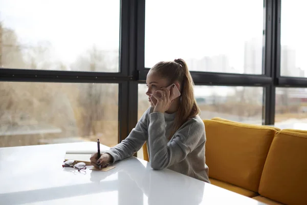 Side view of young professional manager making hotel reservation contact operator.Serious business woman discussing project with colleague talking about successful strategy during mobile conversatio