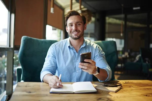 Çalışma programı planlama ve bildirimleri Smartphone'da yapma yakışıklı başarılı işadamı portresi. Müreffeh pazarlama uzmanı online mobil ağlar Brea'daki sohbet mesaj gönderme