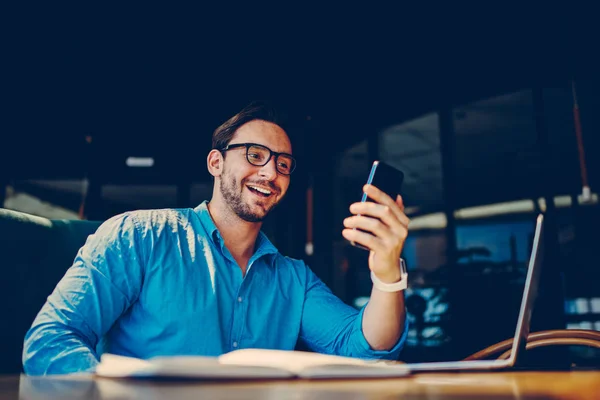 Fröhliche Männliche Freiberufler Glücklich Sms Von Freund Während Der Arbeit — Stockfoto