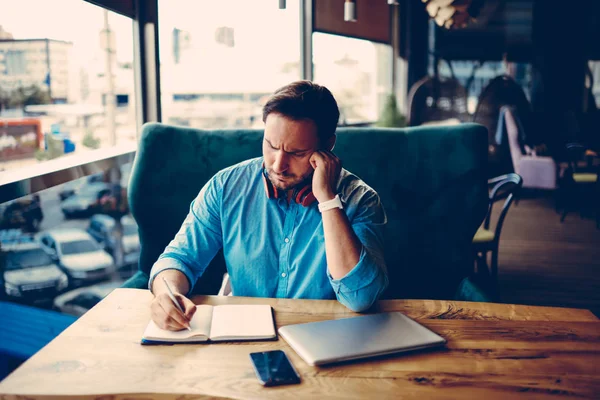 集中的男性企业家做笔记 而计划预算为开始坐在咖啡店 体贴的经理写报告组织工作流程和信息在咖啡馆内部 — 图库照片