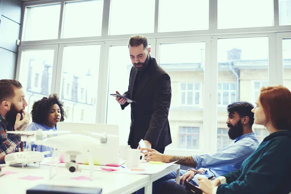 Yakışıklı eğitmen business Management yetenekli çalışan, profesyonel antrenör eğitim ders sırasında aygıt kullanarak modern konferans odasında öğrencilerle konuşma grubu için yapım Atölyesi