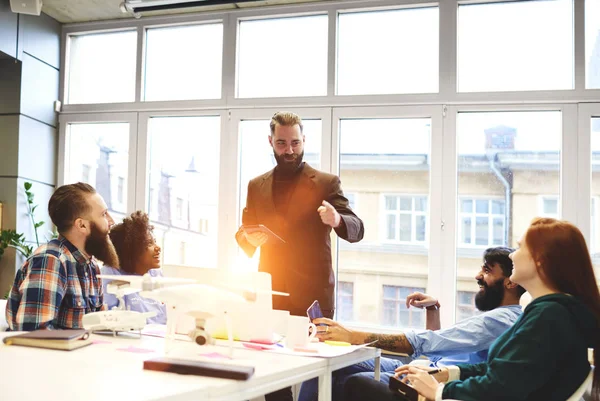 Takım iyi ruh hali, pozitif Koç iş stratejileri erkek ve dişi stajyer grubuna açıklayan yaratıcı fikirler sunan meslektaşları ile iletişim çalışma yetenekli yakışıklı lideri
