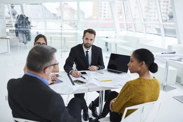 Profesyonel Mimarlar dizüstü kullanarak proje hakkında icra müdürü ile danışmanlık sürecinin çalışma. Resmen işbirliği konferans salonunda görüşme sırasında ayrıntılarını tartışmak iş ortakları