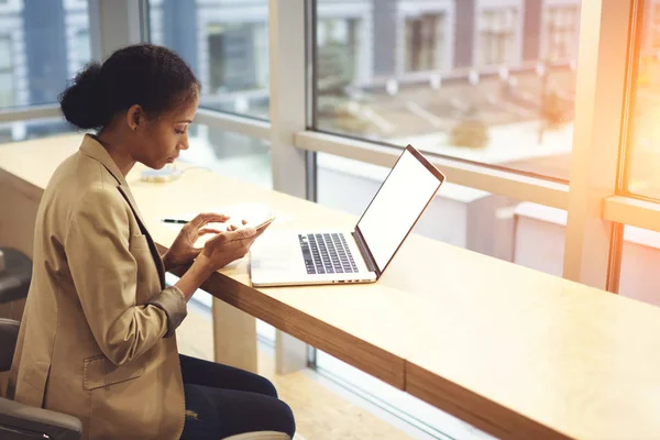 Zakenvrouw met smartphone en laptop — Stockfoto