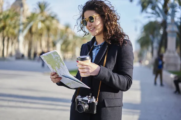 Harita ile lezzetli kahve el açık havada duran üzerinde doğru hedef arama trendy güneş gözlüğü gülümseyen şık hippi kız. İlginç yerler için yolculuk sırasında kamera ile pozitif Gezgin