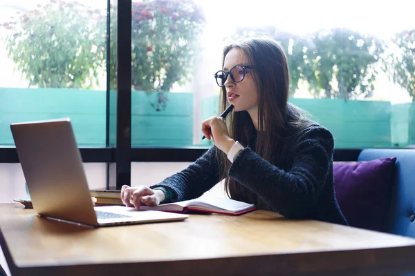 Kız öğrenci bilgi internet üzerinde arama ödev görevleri yerine getirmeye büyüleyici yaratıcı grafik tasarımcısı'nda gözlük online modelleme için dizüstü bilgisayarda uygulama kullanarak proje için fikirler üzerinde durulması