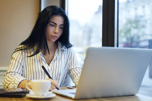 プロフェッショナルなビジネス女性のネットワークで情報を検索は 問題の解決に集中しました コーヒー ショップで財務報告書を計画リモートの仕事をしている魅力的な深刻な女性起業家 — ストック写真