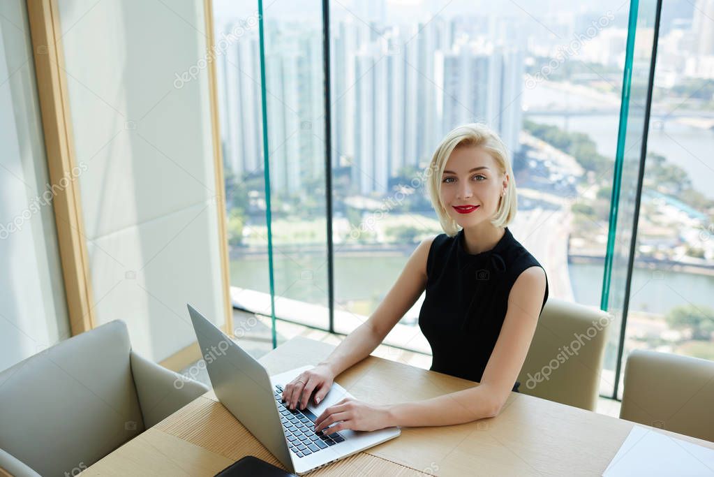 Portrait of proud female CEO working online checking financial report via laptop computer satisfied  with company income,charming businesswoman in formal elegant dress doing remote job in good moo
