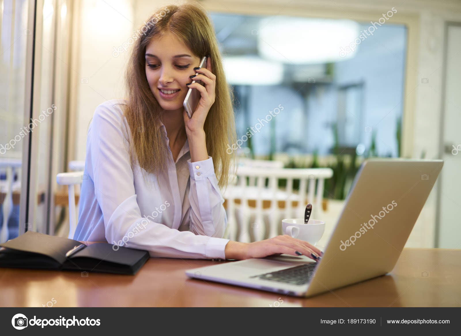 Smiling Businesswoman Making Reservation Online While Talking